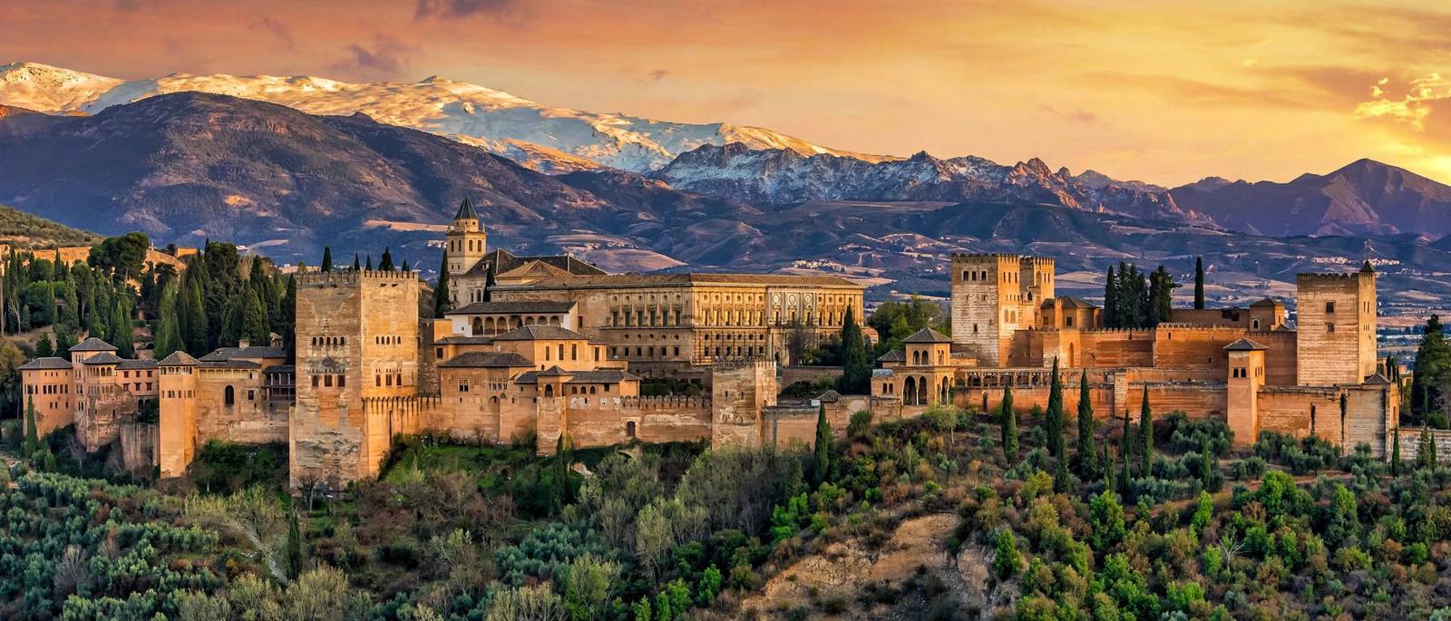 The Alhambra palace in Granada at golden hour with the Sierra Nevada behind