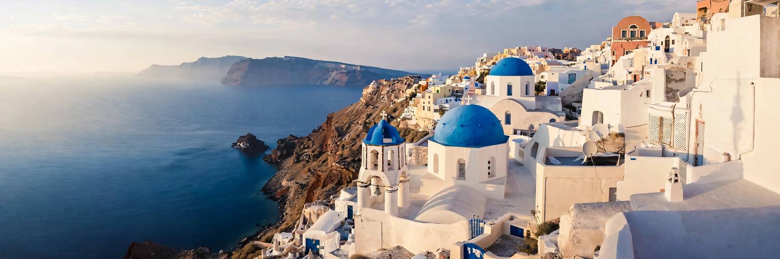 Blue-domed churches and whitewashed houses in Oia, Santorini, Greece